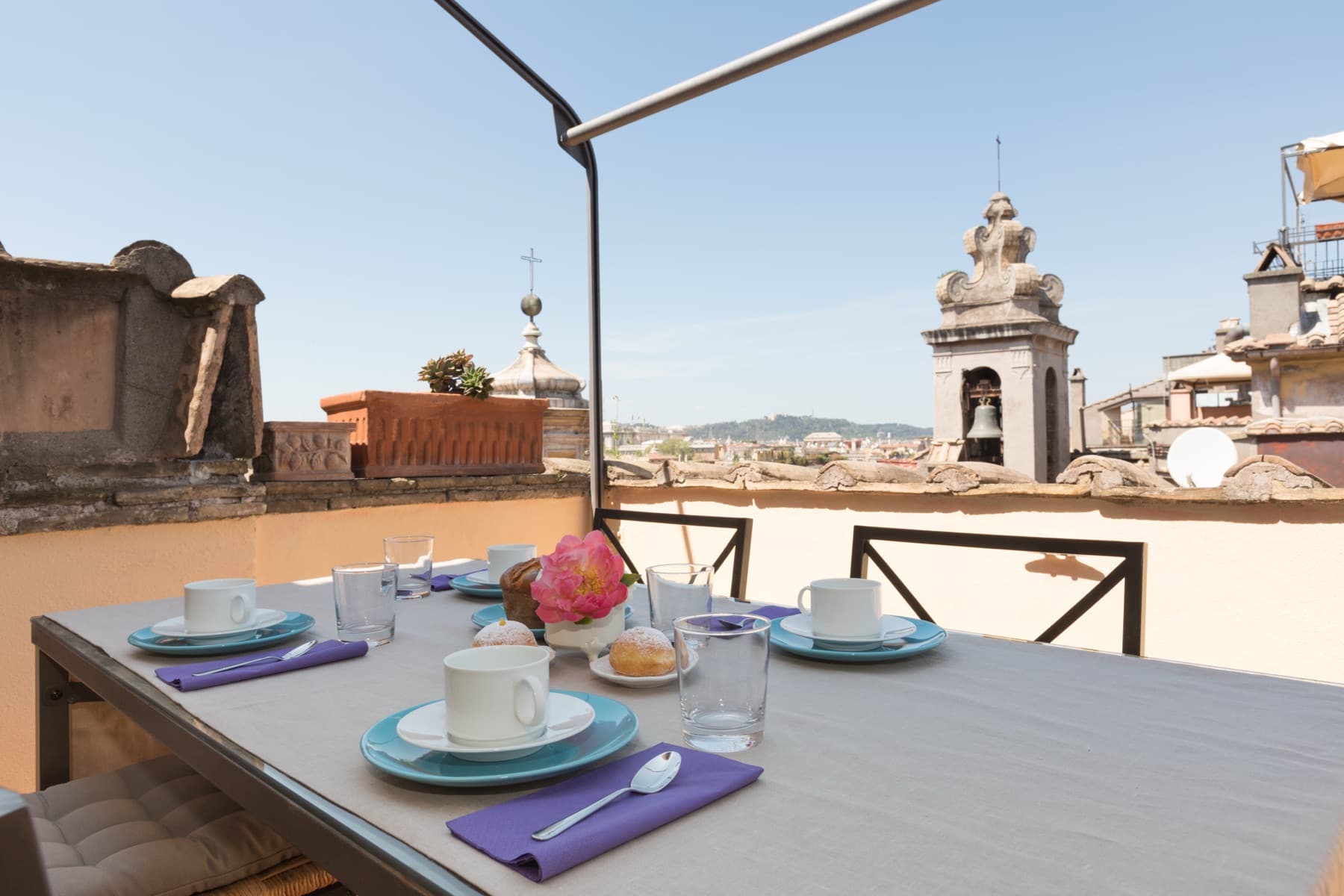 Breakfast table on the private terrace, bell tower behind